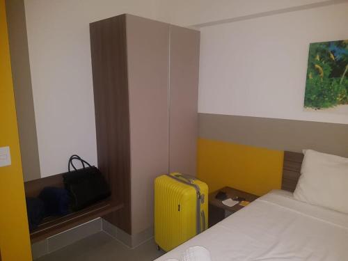 a hotel room with a yellow suitcase next to a bed at Enjoy Olímpia Park Resort in Olímpia