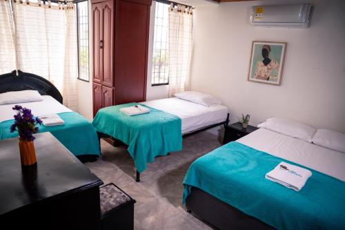 a room with two beds and two tables in it at Casa Marina Espectacular Casa Completa Valledupar in Valledupar