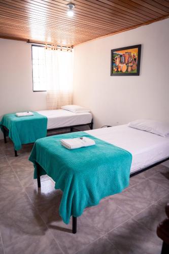 a room with two beds and two tables in it at Casa Marina Espectacular Casa Completa Valledupar in Valledupar
