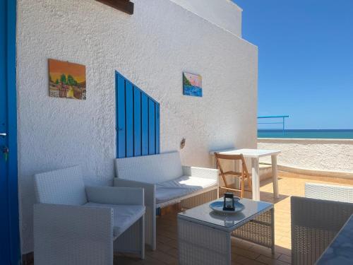 a patio with chairs and a table on a beach at Baia Marina Oasi in Balestrate