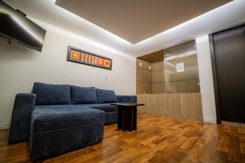 a living room with a blue couch and a table at Hotel Casa ixtapan in Ixtapan de la Sal