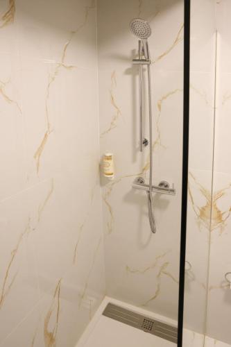Eine Dusche in einem Badezimmer mit weißen Wänden und Marmor in der Unterkunft Hotel Ribadouro in Alijó