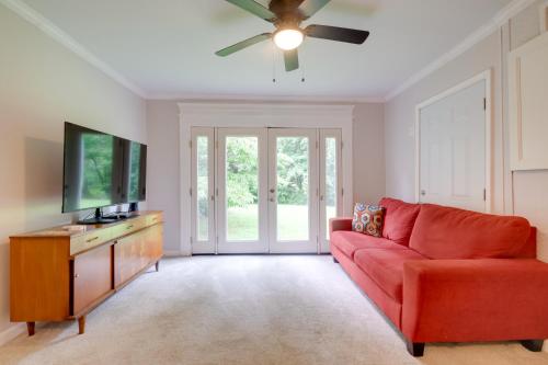 a living room with a red couch and a flat screen tv at Dock Access Waterfront Studio in Colonial Beach! in Colonial Beach
