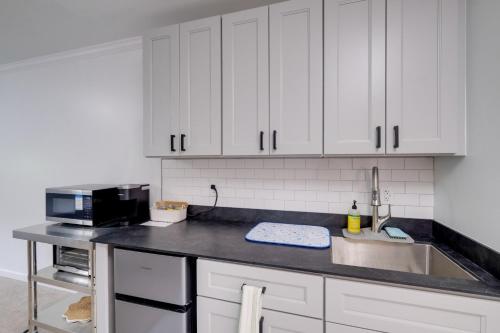 a kitchen with white cabinets and a black counter top at Dock Access Waterfront Studio in Colonial Beach! in Colonial Beach