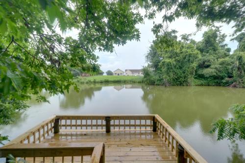 a dock on a lake with a house in the background at Dock Access Waterfront Studio in Colonial Beach! in Colonial Beach