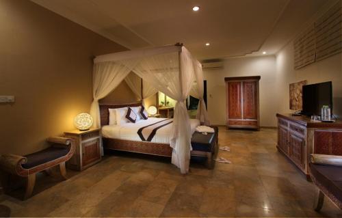 um quarto com uma cama de dossel em Frangipani Villas em Ubud