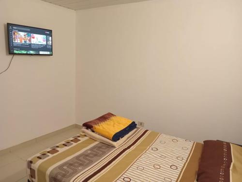 a bed in a room with a tv on the wall at Departamento pequeño y comod in Fernando de la Mora