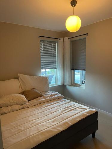 a bedroom with a bed with a light on the ceiling at Semi-detached house with lovely views of the city fjord in Askøy