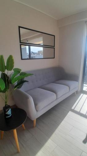 a white couch in a living room with a mirror at Departamento Central Vip in Antofagasta