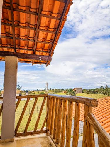 a balcony with a wooden railing and a roof at Chalé sol de Macapá 1- Sua Casa pertinho do Mar in Luis Correia
