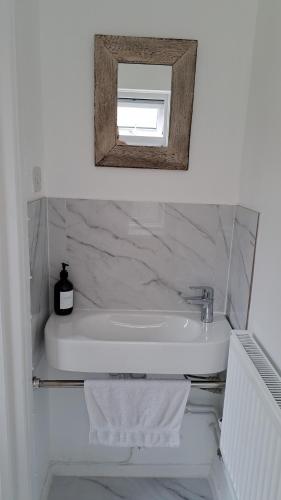 a bathroom with a white sink and a mirror at 3 Bed House Sleeps 6 In Calne in Calne