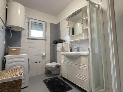 a white bathroom with a toilet and a sink at Zen in Umag