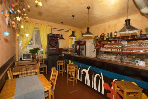 a restaurant with a bar with wooden tables and chairs at Hostel pod Voglom in Bohinj