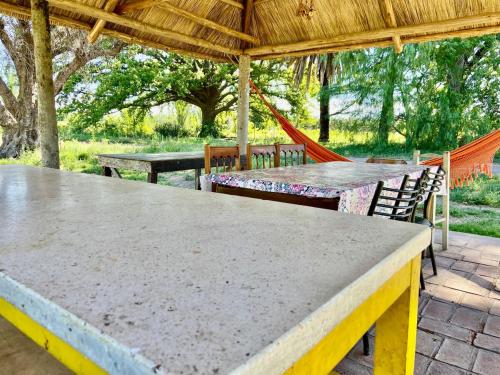 un patio con 2 mesas, sillas y una hamaca en Private bedroom with bathroom, en San Rafael