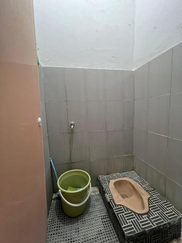 a bathroom with a bucket and a toilet at D' Mande Homestay Bukittinggi in Bukittinggi