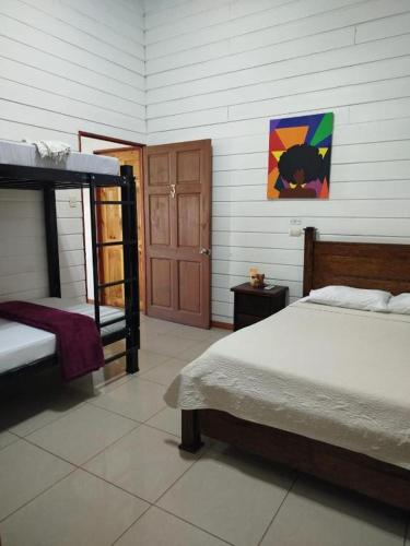 a bedroom with two bunk beds and a door at Liahs tortuguero in Tortuguero