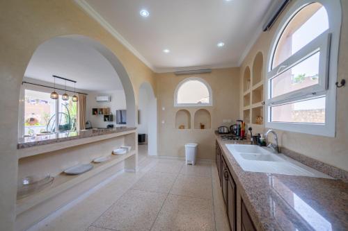 a large bathroom with two sinks and two windows at Ocean Breeze Retreat Steps from the Tiznit Shore in Tamellalt