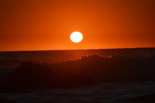 a sunset over the ocean with the sun in the sky at Amazing Rooftop Views and Free Parking in Mirasol in Mirasol