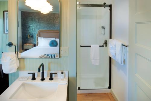 a bathroom with a sink and a mirror and a bed at Hotel Sylvia in Newport