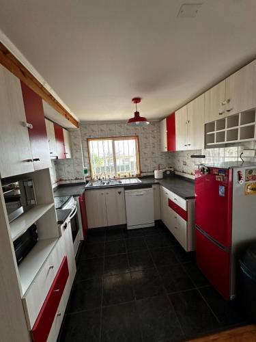 a kitchen with white and red cabinets and a red refrigerator at Amazing Rooftop Views and Free Parking in Mirasol in Mirasol