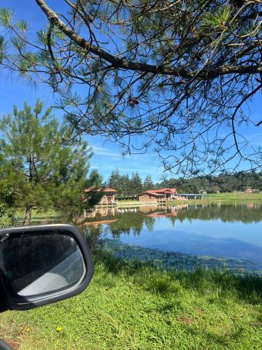 a view of a lake from a car mirror at Cabañas el lago in Zacatlán