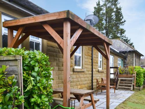 a wooden pergola over a picnic table on a patio at The Waiting Room in Falstone