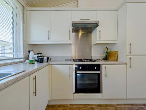 a kitchen with white cabinets and a stove top oven at 2 Bed in Stepaside 91799 in Stepaside