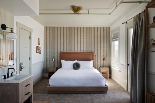 a bedroom with a white bed and a sink at Hotel Sylvia in Newport