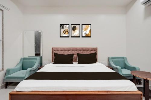 a bedroom with a bed and two blue chairs at Hotel O Shagun hotel and Banquets in Gomti Nagar