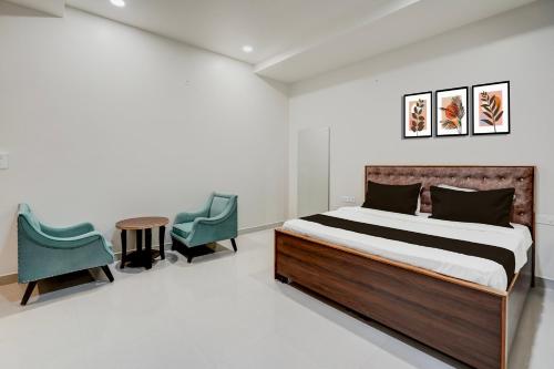 a bedroom with a bed and two chairs at Hotel O Shagun hotel and Banquets in Gomti Nagar