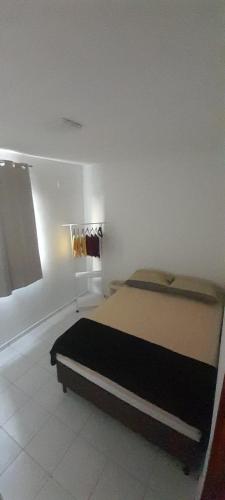 a bedroom with a bed in a white room at Ap no Turu, 10 min das praias in São Luís