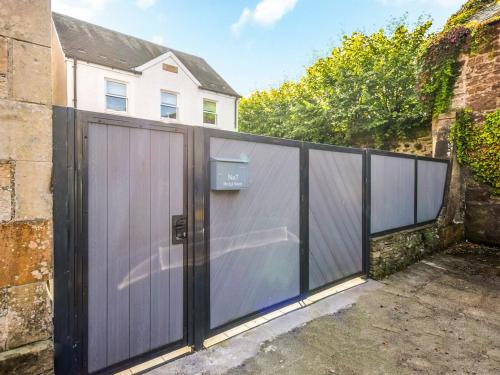 a wooden fence with a gate in front of a house at The White House in Callander