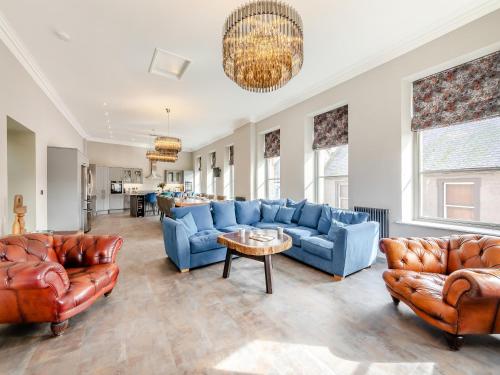 a living room with blue couches and a table at The Embassy in Eyemouth