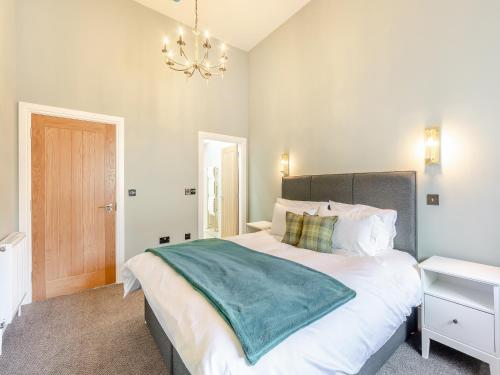 a bedroom with a large bed and a chandelier at The Embassy in Eyemouth