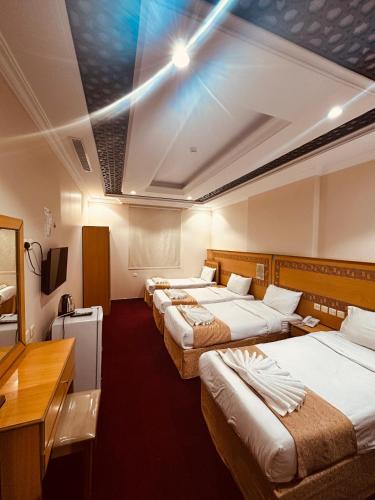 a hotel room with four beds in a row at Ghazala Beautiful Hotel shuttle service to the Haram in Mecca