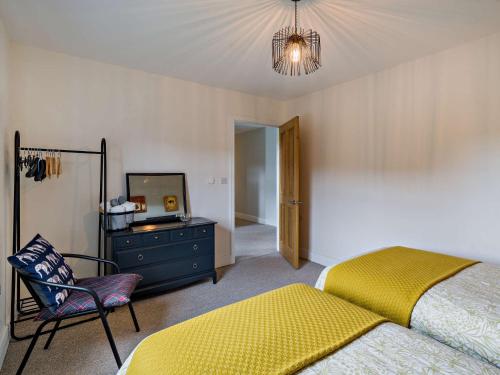 a bedroom with a bed and a chair and a mirror at 4 Bed in Hayton SZ119 in Hayton