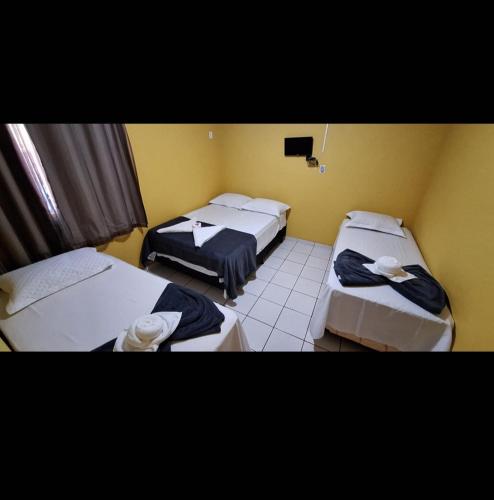 a room with three beds in a room at Pousada Alma Jalapoeira - Mateiros in Mateiros
