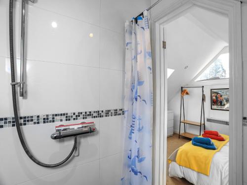 a bathroom with a shower and a bed at The Lodge in Carlyon Bay
