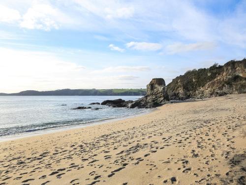 a sandy beach with footprints in the sand at The Lodge in Carlyon Bay
