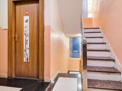 una scala in una casa con porta in legno di Hotel O Sharda a Gwalior