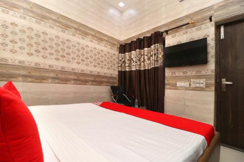 a bedroom with a bed and a flat screen tv at Hotel O Max in Jalandhar