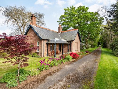 une maison sur un chemin de terre fleuri dans l'établissement 2 Bed in Kirriemuir 86235, à Logie