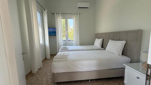 a bedroom with two beds and a window at Magdalini Garden House in Paralion astros