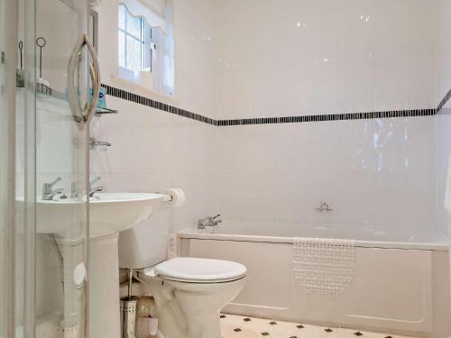 a white bathroom with a toilet and a sink at 2 Bed in Shanklin IC004 in Shanklin
