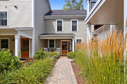 a house with a brick walkway leading to the front door at Base Camp at Village Walk E in Stowe