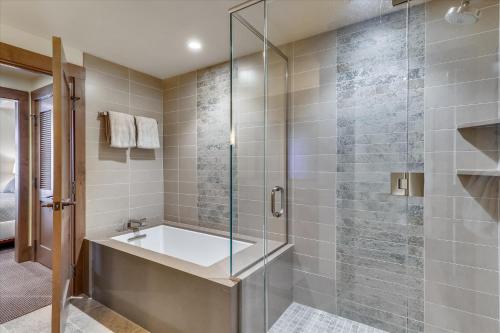 a bathroom with a tub and a glass shower at Spruce Adventure in Stowe