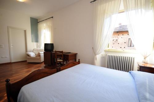 a bedroom with a bed and a window and a couch at Guest House Domus Urbino in Urbino