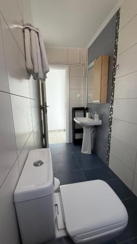 a bathroom with a white toilet and a sink at Magdalini Garden House in Paralion astros