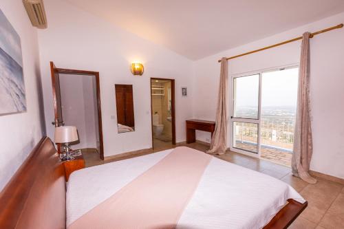 a bedroom with a white bed and a large window at Carpe Diem in Faro