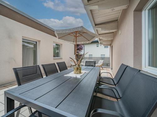 a dining room table with chairs and an umbrella at Haus Enn in Neukirchen am Großvenediger